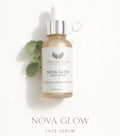 Nova Glow glycolic serum in a clear bottle with a dropper, featuring a silver cap and label, surrounded by green leaves.